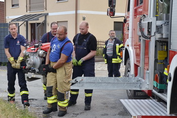 Feuerwehrkameraden beim Verladen der Tragkraftspritze